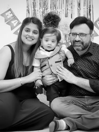 A classic family portrait from a first birthday shoot, presented in black and white for a timeless look.