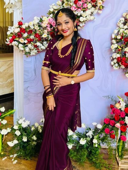 The client in her purple saree, smiling for the camera. The blouse has delicate embroidery on the sleeves.