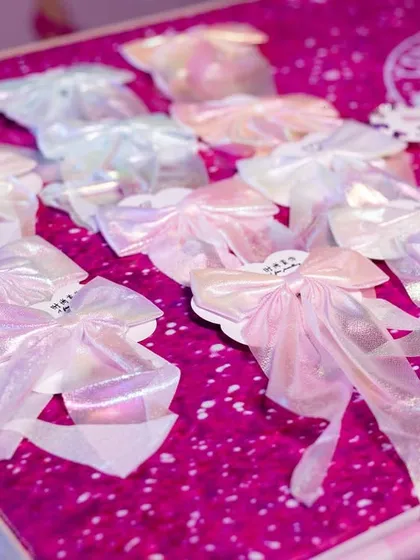 Beautiful, iridescent bows laid out as party favors for the Barbie-themed celebration.