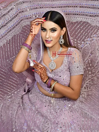 A model in a lavender lehenga, showcasing a modern and chic bridal or reception look. This demonstrates the versatility of our students' skills beyond traditional red and pink.