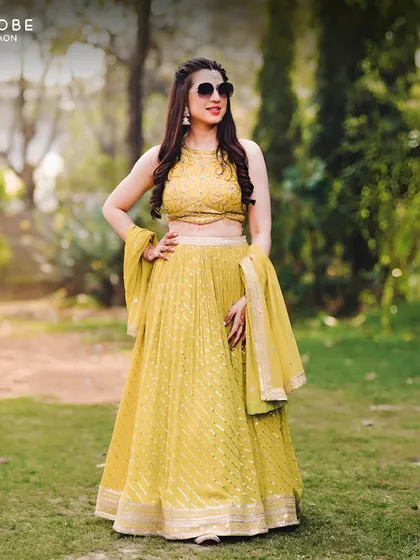 A full view of the sunshine-yellow lehenga, perfect for a Haldi or Mehendi ceremony. The sunglasses add a cool, modern vibe to the whole look.