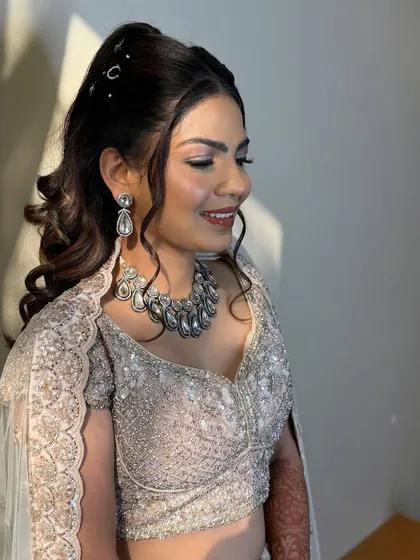 A sun-kissed moment before the sangeet. The light catches the shimmer in her makeup, creating a beautiful, radiant effect.
