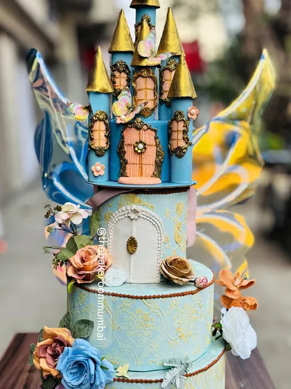 A fairytale brought to life. This multi-tiered princess castle cake features intricate, hand-sculpted details and kinetic butterfly wings that appear to flutter, creating a truly magical centerpiece for a grand celebration.