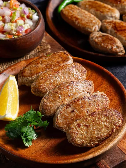 We also shoot other varieties like these seekh kebabs, styled simply on a wooden plate to highlight their shape and texture, accompanied by a fresh salad.