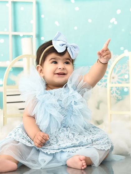 Pointing to the sky in her winter wonderland. This first birthday shoot captures her sense of wonder and excitement.