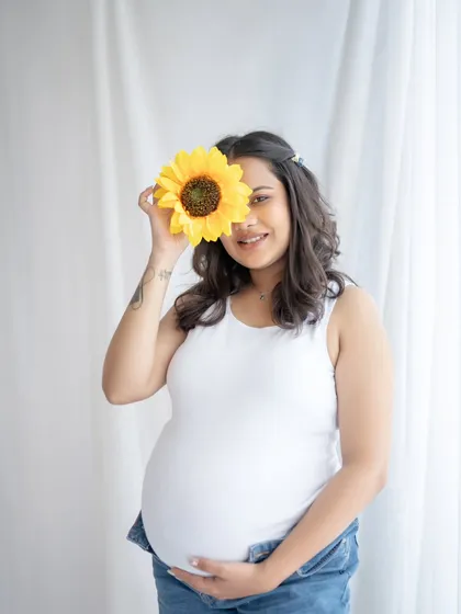 A little bit of fun with a sunflower prop. This playful solo portrait is simple, sweet, and shows that maternity photos can be lighthearted and cheerful.
