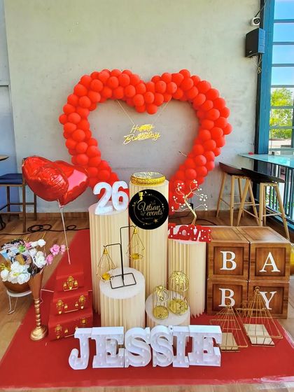 A heart-shaped red balloon arch for a 26th birthday. This setup is perfect for celebrating love, whether for a birthday or an anniversary.