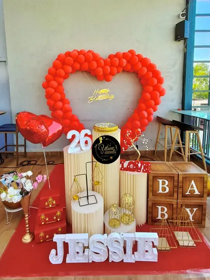 A heart-warming birthday surprise featuring a heart-shaped red balloon arch. This romantic theme is perfect for celebrating a loved one.