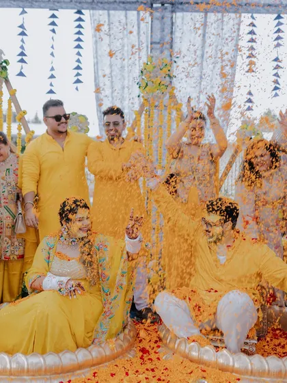 An explosion of joy and marigold petals as friends and family shower the couple during their Haldi ceremony.