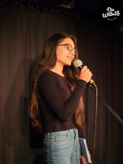 A performer sharing her poetry with a responsive and supportive crowd.