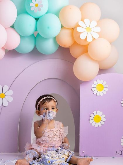 A pretty pastel and daisy themed cake smash. This little one is covered in purple frosting and loving it. The custom built rainbow prop adds a unique touch.