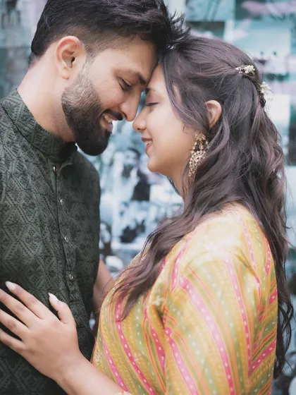 A romantic close-up of a couple, their foreheads touching. The soft lighting and their gentle smiles make this a classic and heartfelt pre-wedding portrait.