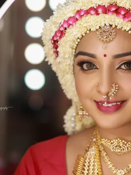 A close-up of the Sharadha Jalli, captured with a ring light to ensure every detail of the makeup and the floral headpiece is perfectly illuminated.