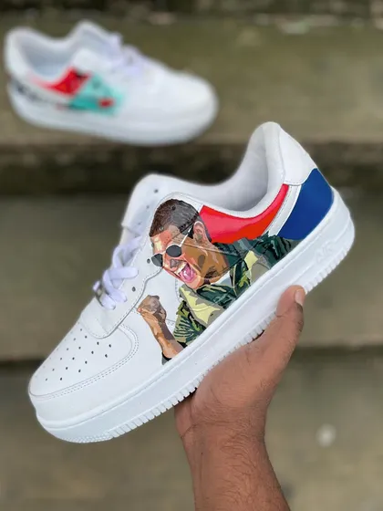 A hand-held shot of the Tom Cruise portrait shoe from the 'Top Gun' set. The detailed painting captures his triumphant expression from the movie.