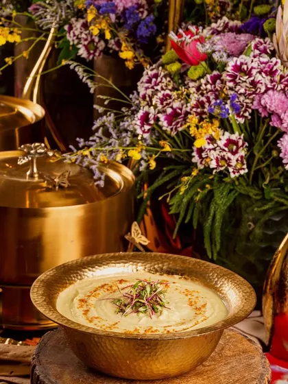 Our elegant brass serving dishes and vibrant floral decor create a visually stunning buffet setup for any luxury event.