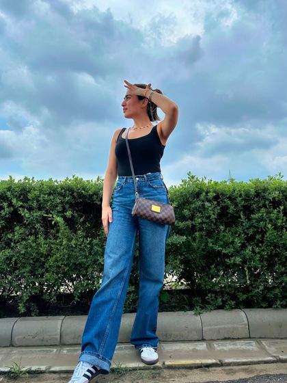 A simple yet classic outfit: a black tank top paired with wide-leg blue jeans and sneakers. It's my go-to for a comfortable and stylish look.