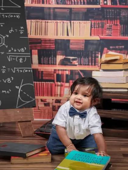 A little scholar in the making! This 'genius' theme features a library backdrop, stacks of books, and a chalkboard with complex equations for a smart and cute photoshoot.
