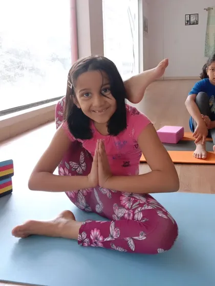 Look at that smile. This young yogi is mastering Eka Pada Sirsasana, or the leg-behind-head pose, with confidence. My goal is to help every child feel proud of their progress, no matter the pose.