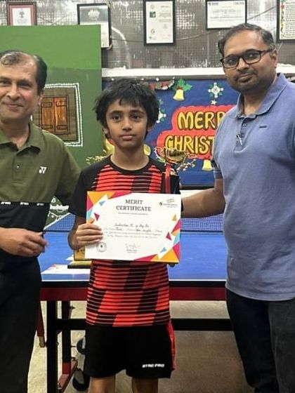 A young player proudly holds his merit certificate. We believe in recognizing and encouraging talent at every stage of their development.