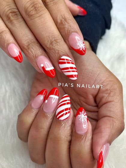 Another take on a red Christmas theme, with candy cane stripes, snowflakes, and Santa hat French tips.