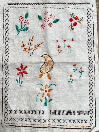 The sampler created by my 11-year-old student. It shows her practice of various basic stitches, from running stitch and cross stitch to simple floral motifs.