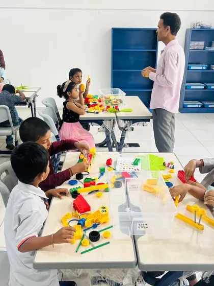 A classroom at The School for Global Minds filled with young learners exploring STEM concepts through hands-on LEGO play.