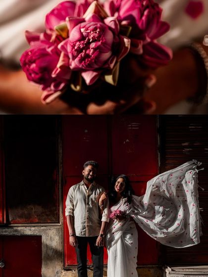 A creative pre-wedding shot featuring a close-up of a lotus bouquet and the couple standing against a bold red wall, the bride's saree flowing in the wind.