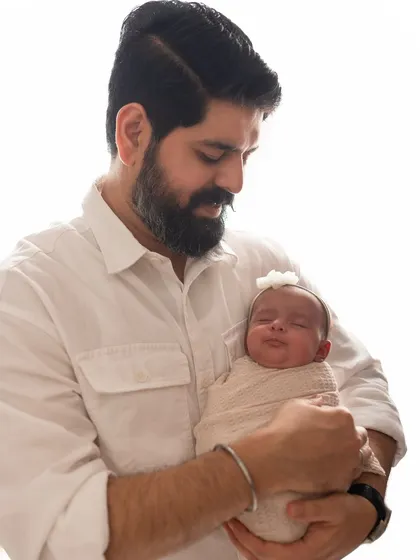 A sweet smile from a sleeping newborn, held safely in her father's arms. It's so magical when I get to capture a sleepy smile.