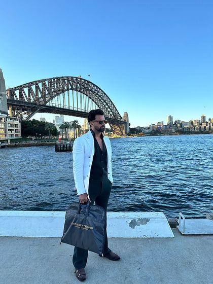Our white slim-fit double-breasted blazer, pictured here against the iconic Sydney Harbour Bridge. A perfect travel companion for the stylish globetrotter.