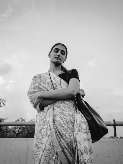 A powerful low-angle shot in black and white. The model's strong stance and determined expression make this a very impactful image.