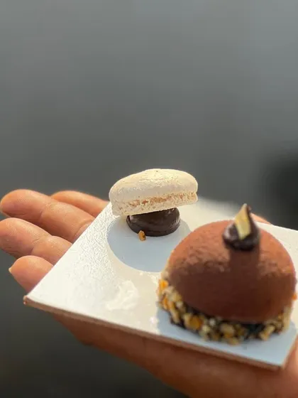 My "Monalisa" dessert, a chocolate dome filled with an almond praline crunch. It's served with a delicate macaron for a multi-textured dessert experience.