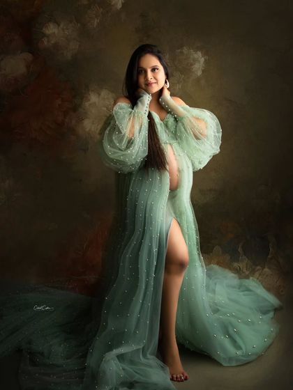 This mom-to-be looks like a goddess in a sheer, mint green gown with pearl details and dramatic puffy sleeves.
