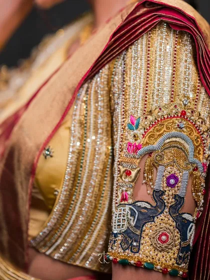 Detailing that tells a story. This close-up reveals the exquisite hand embroidery on a bridal blouse sleeve, featuring a majestic elephant motif, a symbol of royalty and strength. The intricate zardosi and threadwork are a testament to our dedication to heritage crafts.
