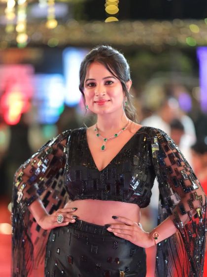 Actress Anusha Rai looking chic in a black sequined outfit, posing confidently for the camera.