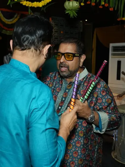 Interacting with guests during a Dandiya night. It's all about creating a fun and engaging atmosphere for everyone, both on and off the dance floor.