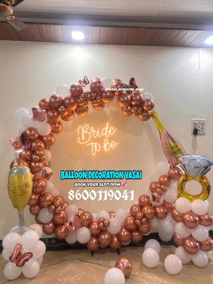 Celebrate the bride-to-be with a fun and trendy setup. This rose gold and white balloon ring arch, complete with a neon sign and playful props, is perfect for party photos.