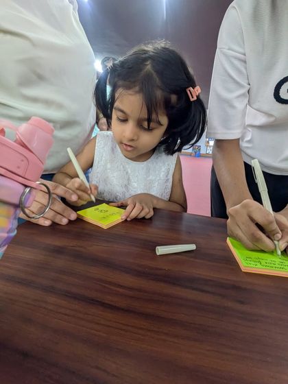 A young attendee enthusiastically participates in our interactive feedback session. We encourage everyone, even the little ones, to engage with art and share what it means to them.