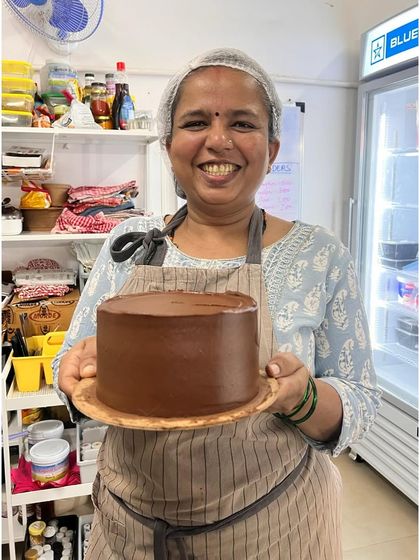 Padma is getting fabulously good at this! Here she is, proudly holding a perfectly frosted chocolate cake. I'm so proud of her progress.