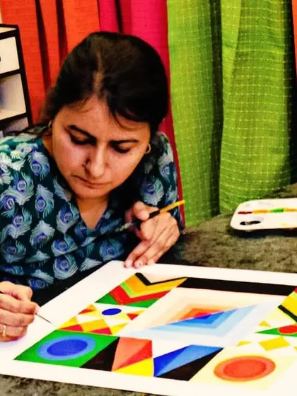 A student works on a complex geometric art piece, carefully applying vibrant colors. My adult art classes are perfect for exploring different styles like abstract and pattern work.