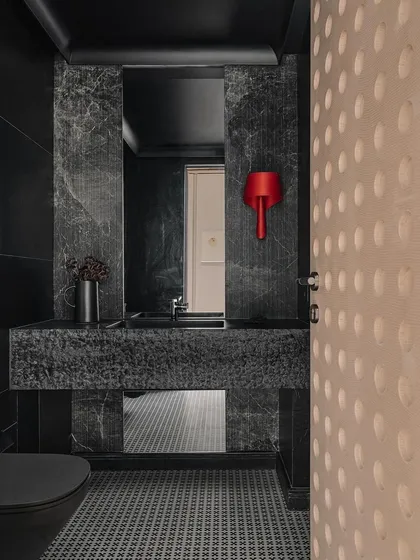 Even the smallest spaces deserve a moment of drama. In the Kanso House powder bath, we used monolithic Basalt stone and a striking red wall light to create a powerful contrast. It’s a testament to my belief that every corner of a home should be thoughtfully considered and beautifully executed.