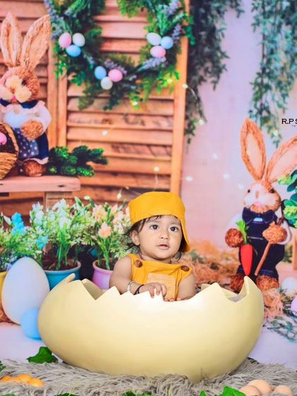 A wider view of the bunny-themed shoot, showing the baby popping out of an egg. This creative and playful setup is perfect for celebrating spring or a pre-birthday milestone.