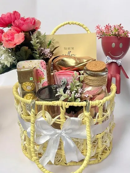 A bright and sunny yellow-themed gift basket for a sister. This cheerful hamper is filled with treats, a cute planter, and other goodies, perfect for celebrating Rakhi.