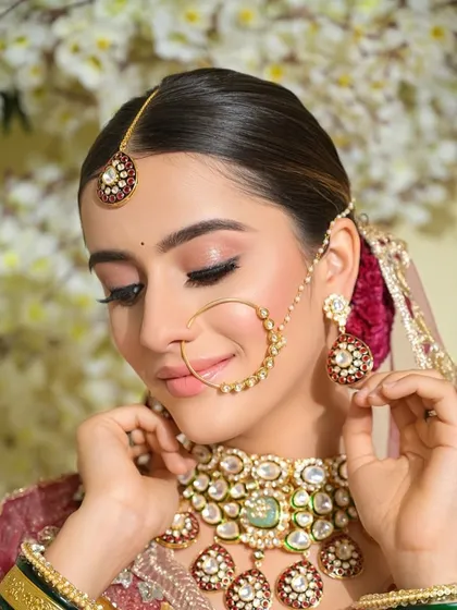 A stunning bride with minimal makeup that lets her natural beauty shine. The sleek bun and statement jewelry complete this elegant and modern bridal look.