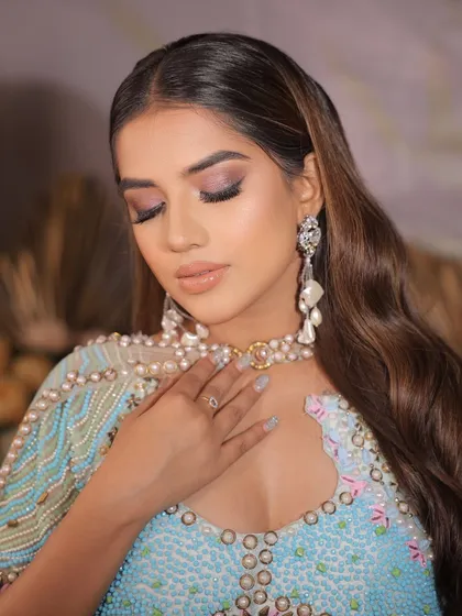 A close-up of a modern cocktail look. The purple and blue toned smokey eye is paired with a glossy nude lip for a high-fashion feel.