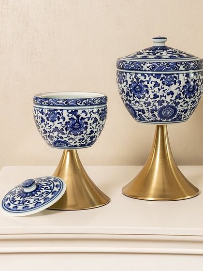 Here is another variation of my blue pottery jars, featuring a rounded shape on a sleek, conical brass stand. The removable lids make them practical for storage, while the design itself is a beautiful decorative element.