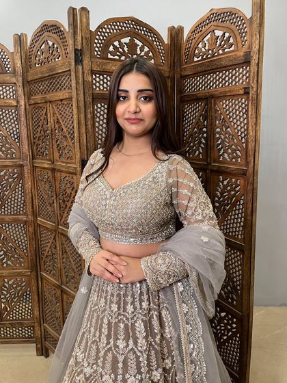 A close-up of the model in the grey lehenga, showing the detailed embroidery on the full-sleeve blouse and the soft, elegant look of the outfit.