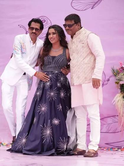 A sweet family moment captured at the carnival event, with the bride posing with her family against the pretty pastel backdrop.