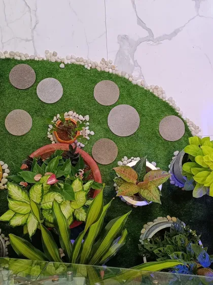 An overhead view of a small garden nook I designed. This shows the combination of artificial turf, circular stone steppers, and a variety of potted plants to create a dynamic and interesting ground cover, even in a limited space.