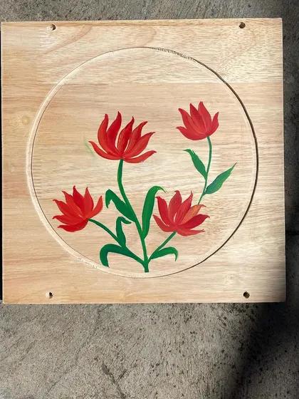 A set of four stylized red tulips painted on a light wood board. The simplicity of the design adds to its charm.