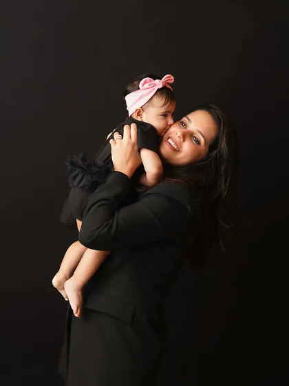A sweet, candid moment as a baby girl gives her mom a kiss on the cheek. These are the unscripted moments that make the most cherished memories.
